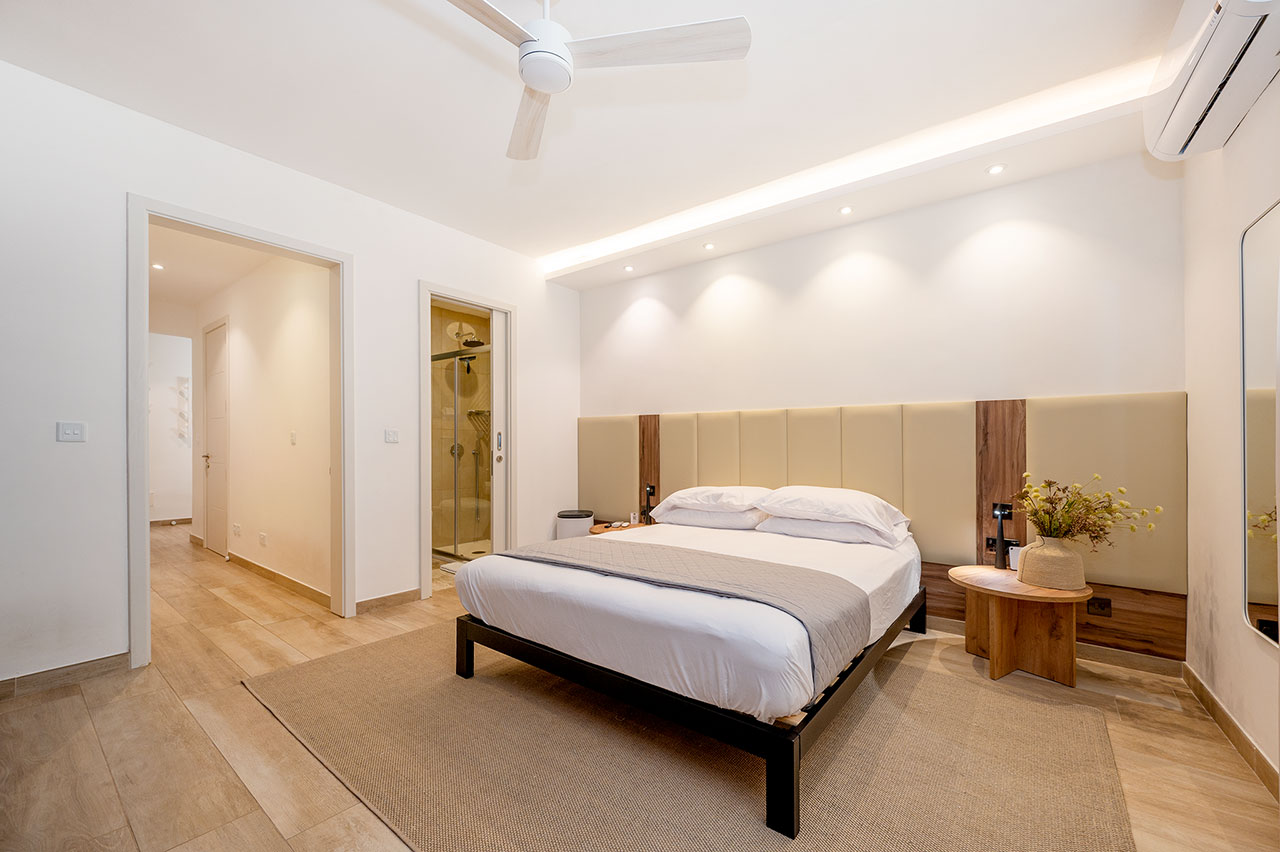 Bedroom with large headboard and soft lighting